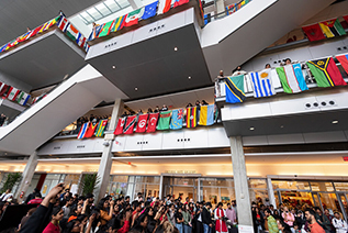 A large crowd of students look at the Campus Center Atrium from both the ground floor and higher levels of the building during the IU Indianapolis annual international festival. 