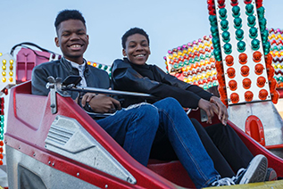 Two students look down as they are smiling during a carnival ride at IU Indianapolis' Jagapalooza Carnival