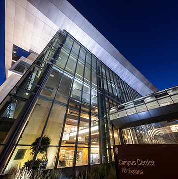 An image of the Campus Center at IU Indianapolis at night. The glass, steel, and stone building glows in the night sky.