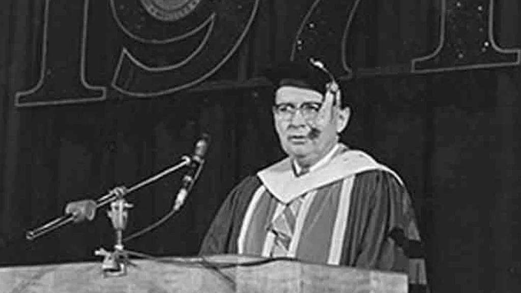 Chancellor Maynard K. Hine speaks at the podium during the at the 1971 commencement ceremony.