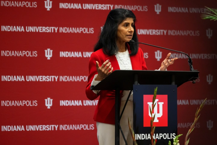 Chancellor Ramchand speaks in front of an IU backdrop at a podium
