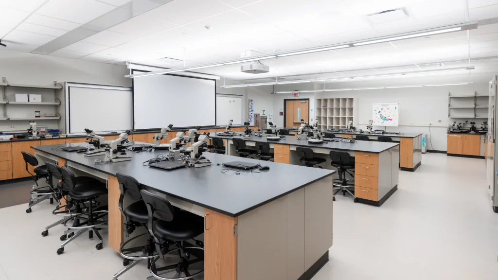 Modern laboratory with rows of microscopes on black-topped workstations.