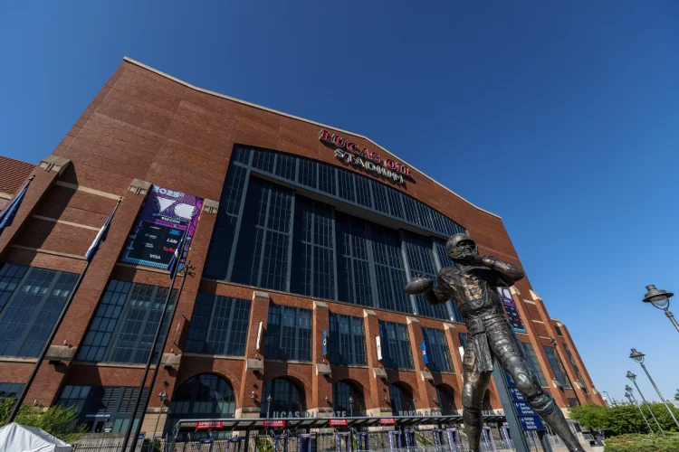 A bronze statue of Peyton Manning stands outside of Lucas Oil Stadium.