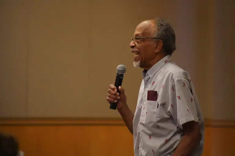 Speaker with a microphone addressing a crowd