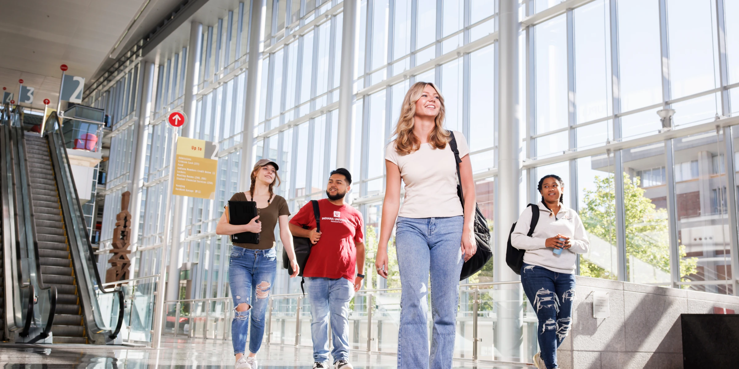 A group of students walk confidently through the IU Indianapolis Campus Center atrium.