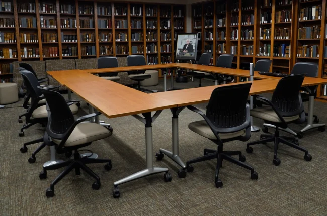 A square table surrounded by chairs sits in a room of bookshelves at the Ruth Lilly Medical Library.